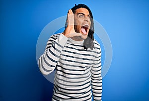 Young handsome african american afro man with dreadlocks wearing casual striped sweater shouting and screaming loud to side with