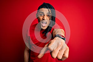 Young handsome african american afro man with dreadlocks wearing red casual t-shirt pointing displeased and frustrated to the