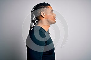 Young handsome african american man with dreadlocks wearing black casual sweater looking to side, relax profile pose with natural