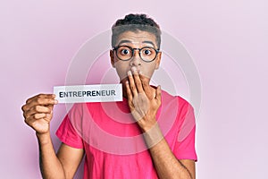 Young handsome african american man holding entrepreneur paper covering mouth with hand, shocked and afraid for mistake