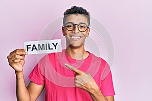 Young handsome african american man holding family paper smiling happy pointing with hand and finger