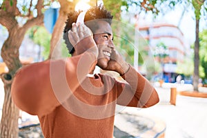 Young handsome african american man listening to music using headphones