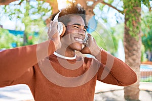 Young handsome african american man listening to music using headphones