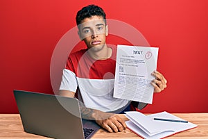 Young handsome african american man showing failed exam thinking attitude and sober expression looking self confident photo