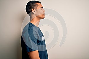 Young handsome african american man volunteering wearing t-shirt with volunteer message looking to side, relax profile pose with