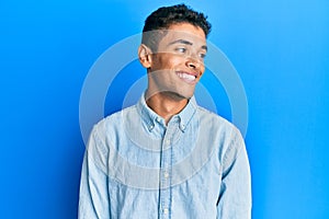 Young handsome african american man wearing casual clothes looking to side, relax profile pose with natural face and confident