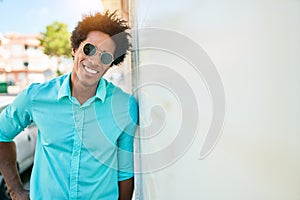 Young handsome african american man wearing casual clothes and sunglasses smiling happy