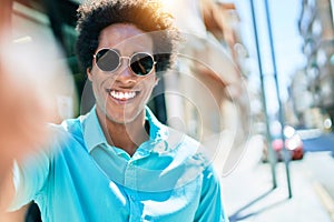 Young handsome african american man wearing casual clothes and sunglasses smiling happy