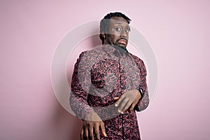 Young handsome african american man wearing casual shirt standing over pink background disgusted expression, displeased and