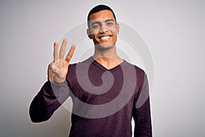 Young handsome african american man wearing casual sweater over white background showing and pointing up with fingers number three