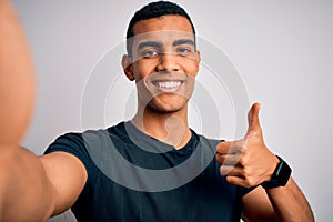 Young handsome african american man wearing casual t-shirt making selfie by camera happy with big smile doing ok sign, thumb up