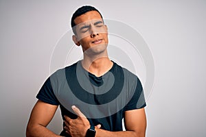 Young handsome african american man wearing casual t-shirt standing over white background with hand on stomach because