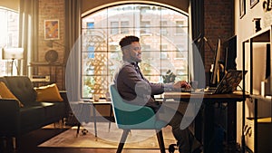Young Handsome African American Man Working from Home on Desktop Computer in Sunny Stylish Loft