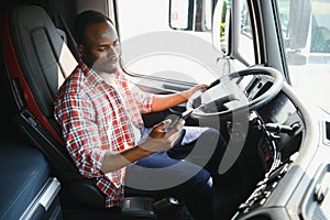 Young handsome African American man working in towing service and driving his truck.