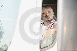 Young handsome African American man working in towing service and driving his truck.