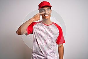 Young handsome african american sportsman wearing striped baseball t-shirt and cap Pointing with hand finger to face and nose,