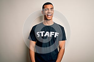 Young handsome african american worker man wearing staff uniform over white background winking looking at the camera with sexy