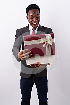 Young handsome African businessman holding gift box against whit