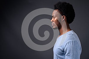 Young handsome African man against gray background