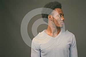 Young handsome African man against gray background