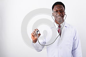 Young handsome African man doctor using stethoscope against whit