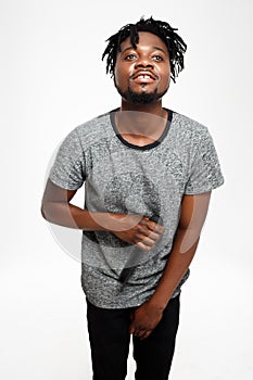 Young handsome african man singing in microphone over white background.