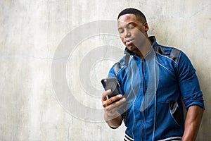 Young handsome African man using mobile phone