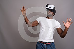 Young handsome African man using virtual reality headset against