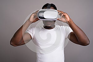 Young handsome African man using virtual reality headset against