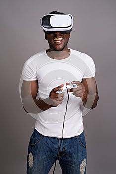 Young handsome African man using virtual reality headset against