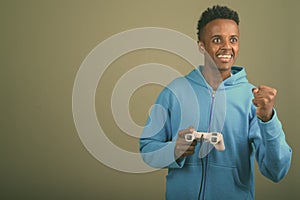 Young handsome African man wearing hoodie against colored background
