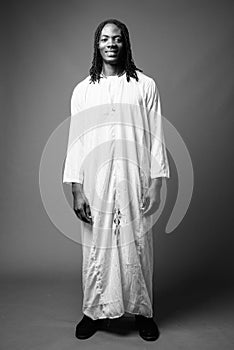 Young handsome African man wearing traditional clothes in black and white