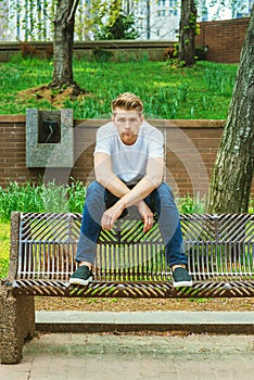 Young handsome American Man relaxing at street park in New York