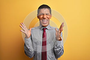 Young handsome arab businessman wearing shirt and tie over isolated yellow background celebrating mad and crazy for success with