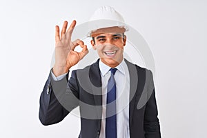 Young handsome architect man wearing suit and helmet over isolated white background smiling positive doing ok sign with hand and