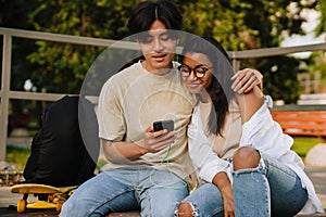 Young handsome asian boy hugging beautiful african girl in glasses