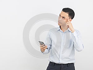 Young handsome asian business man playing smartphone and thinking isolated on white background.