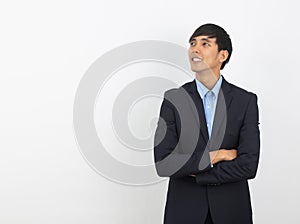 Young handsome asian business man thinking an idea while looking up