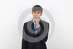 Young handsome asian business man thinking an idea while looking up isolated on white background.
