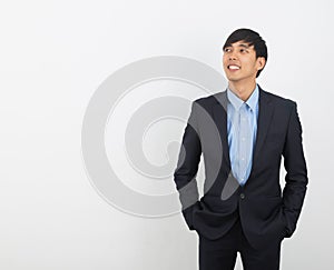 Young handsome asian business man thinking an idea while looking up isolated on white background.