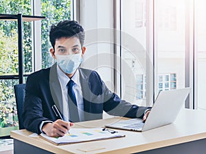 Young handsome Asian businessman in suit in office