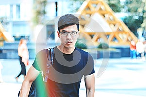 Young handsome asian men wearing casual black tshirt and backpack at day in Sai Gon city, Vietnam