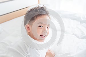 Young boy smiling on bed
