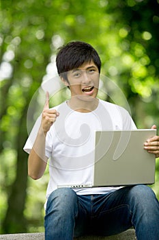 Young handsome Asian student with laptop