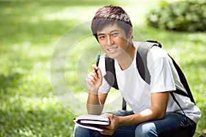 Young handsome Asian student with laptop