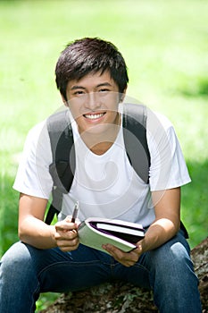 Young handsome Asian student with laptop