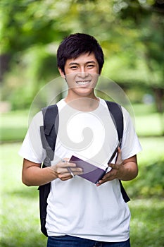 Young handsome Asian student with laptop