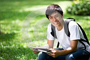 Young handsome Asian student with laptop