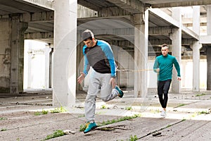 Young handsome athlete men doing exercise in an old abandoned b