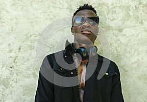Young handsome and attractive athletic African American man in open black denim jacket posing in cool attitude in fashion beauty